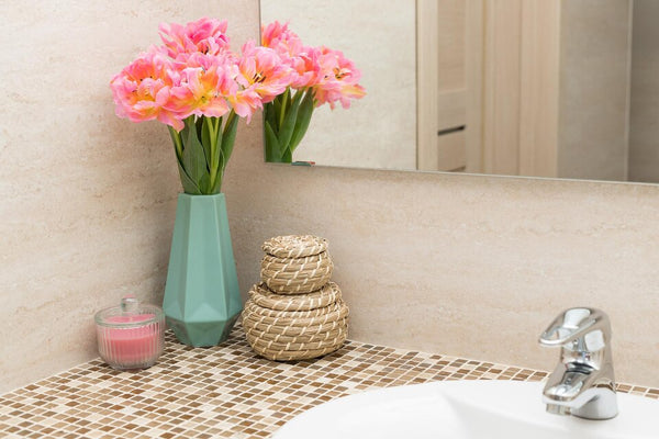 Flowers in a vase placed on a bathroom sink