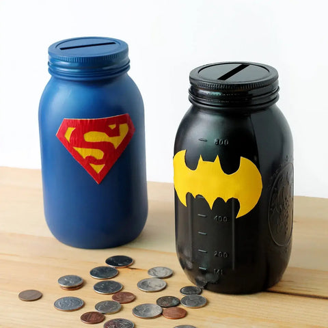 Two glass jars with a slit in their cap along with few coins on a table