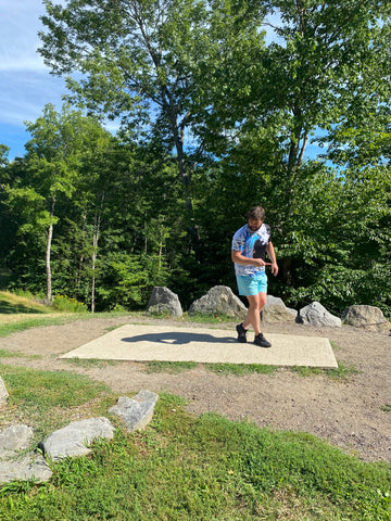 Blogger and lesson instructor at SDG, Andrew Streeter, continues to step 4 of the disc golf X-Step drive, crossing his right foot behind his left.