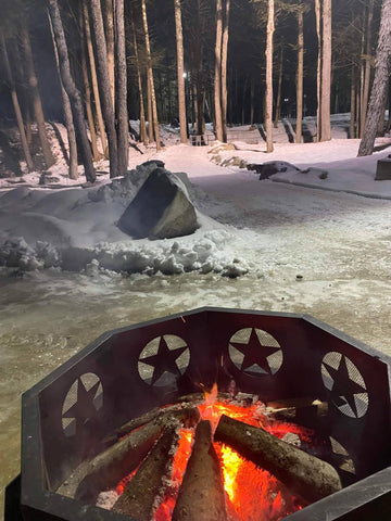 fire pit burning just off the 9 hole owl course during winter night disc golf at sabattus disc golf