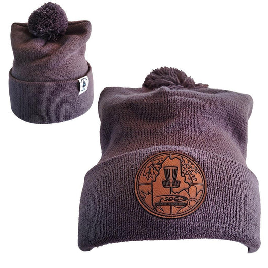 Iron Gray colored Knit Pom Pom Beaning with SDG trainzwholesale Laser Engraved on leather patch that is sewn to the front of the hat, also a back view of the hat with the Rogue Life Maine logo on a small white tag sewn to the hat rim 