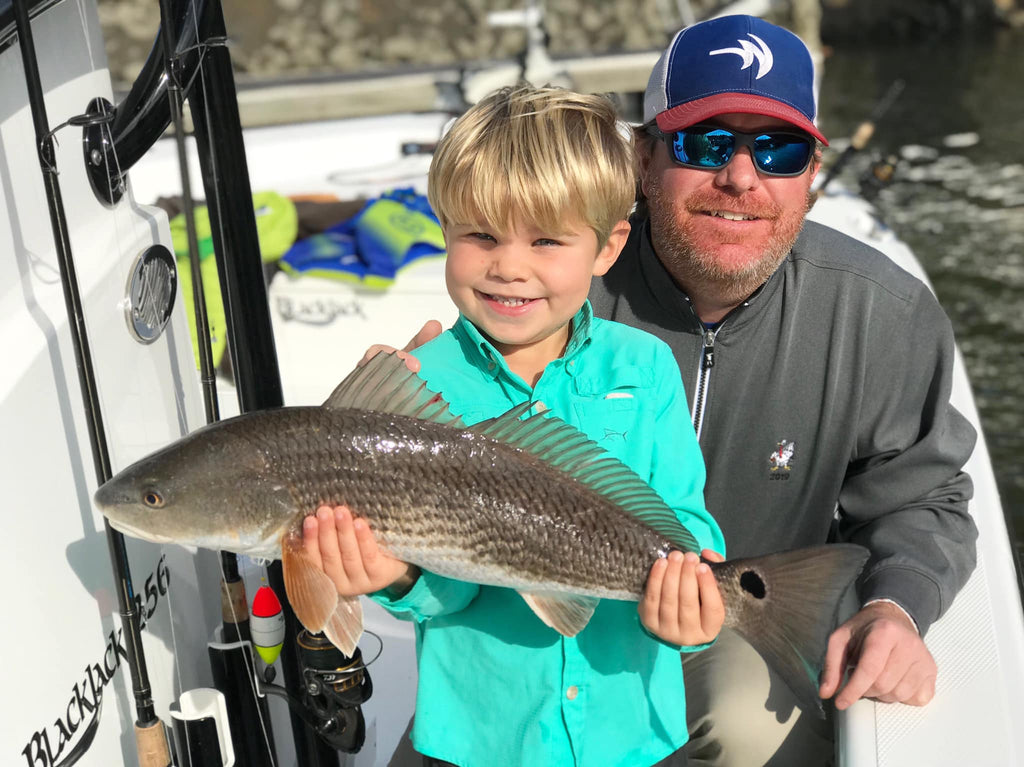 A young angler shows off a beautiful redfish caught recently with Redfin Charters 