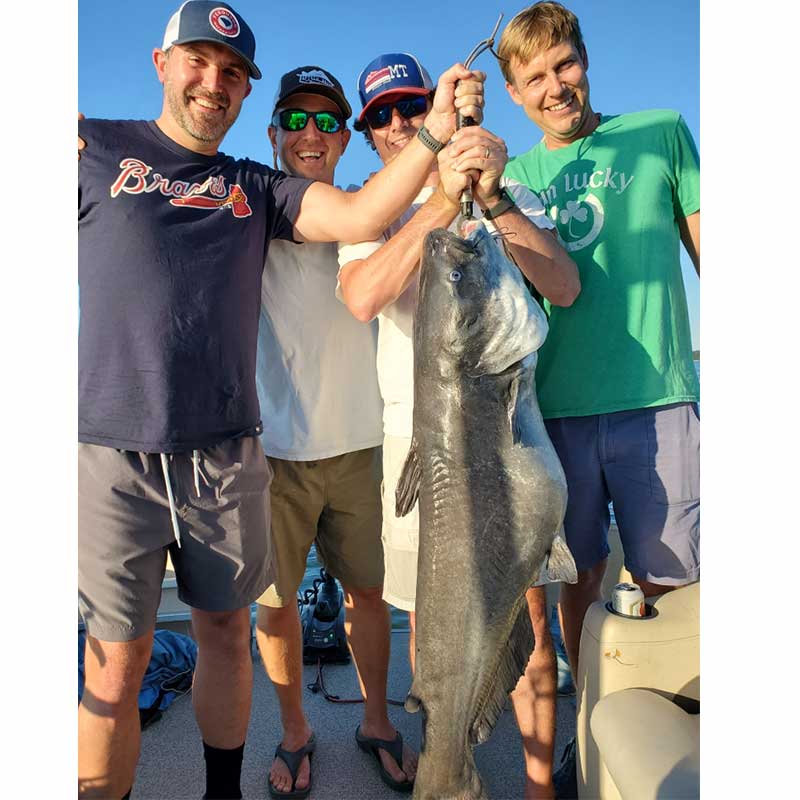 The author (left middle) and friends with a 52-pounder caught Wednesday with Captain William Attaway