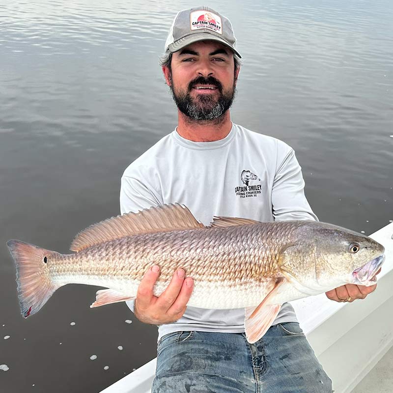 Captain Buddy Love with a strong redfish