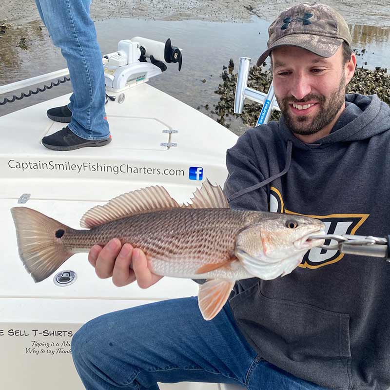 A nice low tide redfish caught with Captain Smiley Fishing Charters