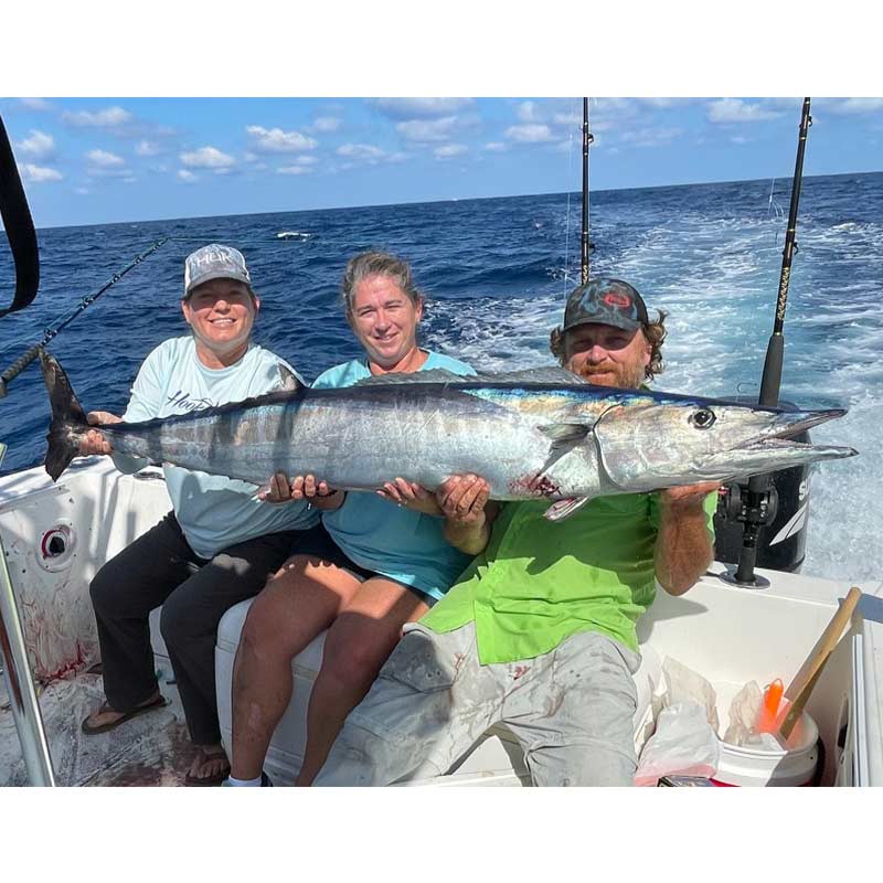 The Baisches and friend with a giant wahoo