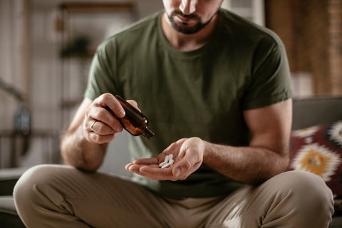 man putting beard growth vitamins in his hand