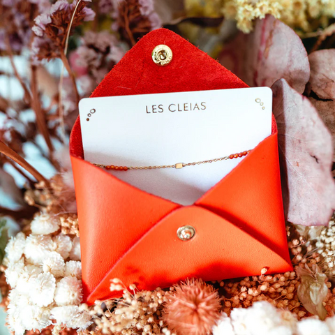 Un bracelet corail et sa pochette en cuir