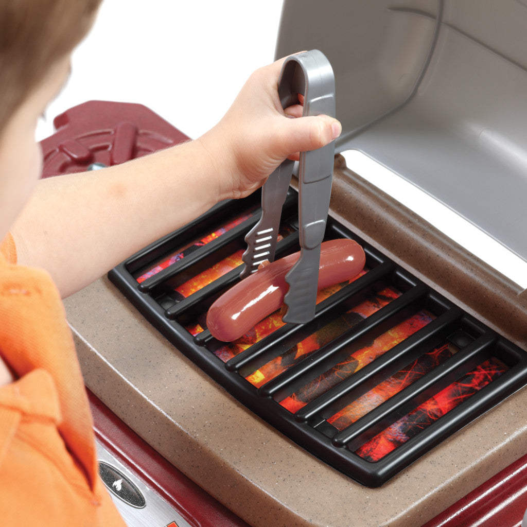 toddler grilling a play food hot dog