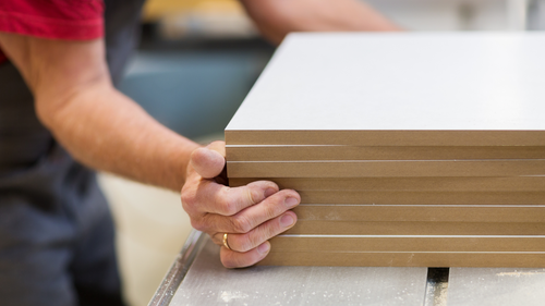 Factory worker cutting MDF boards