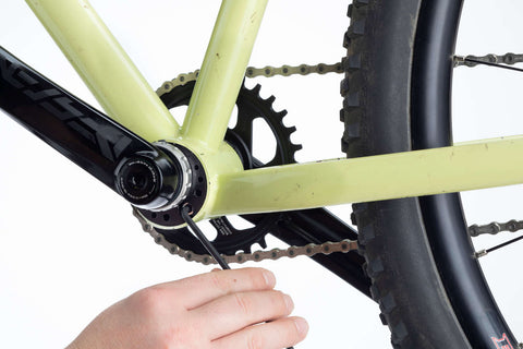 An allen wrench is used to install a crank arm onto the bike.