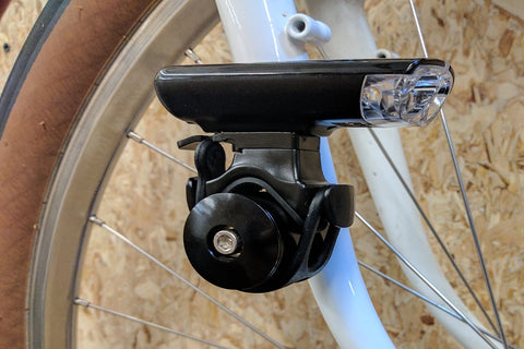 Attached to the fork dropout mounts, near the quick-release nut
