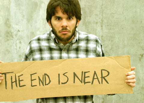 man holding a sign saying the end is near