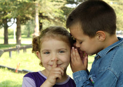 picture of a boy telling a girl a secret