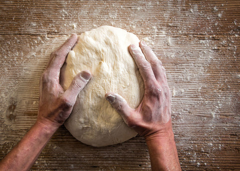 a woman kneading bread