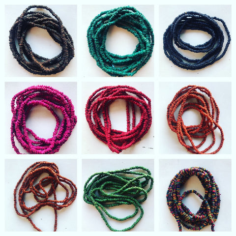 9 beautiful bracelets made of seeds in different vibrant colors. 