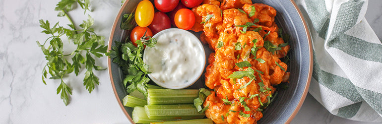 A close-up of vegetarian buffalo cauliflower wings in a bowl.