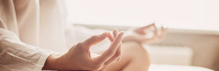 A woman meditating in her home. 