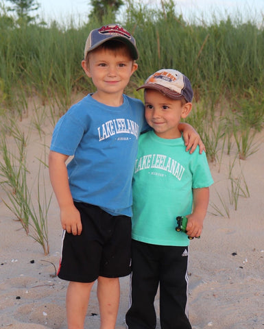 Two boys at Good Harbor beach wearing Lake Leelanau shirts