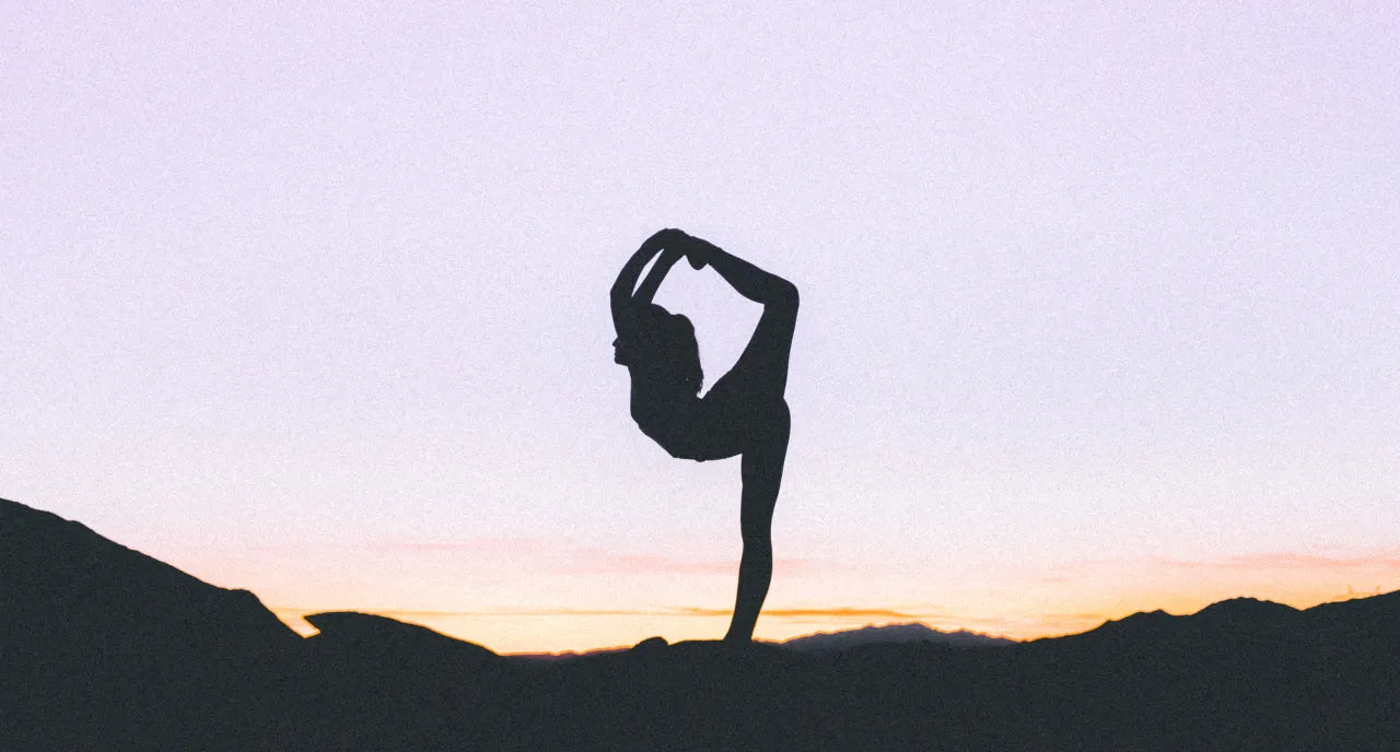 Ragazza che fa yoga al tramonto, controluce e si vede quindi la sagoma, non i dettagli