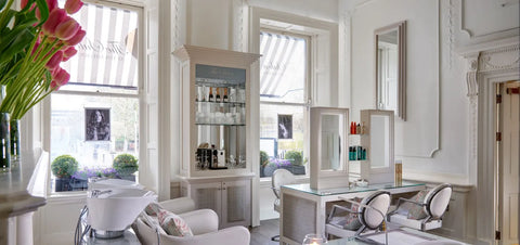 A luxury, white spa treatment room, with spa equipment, chairs and tables