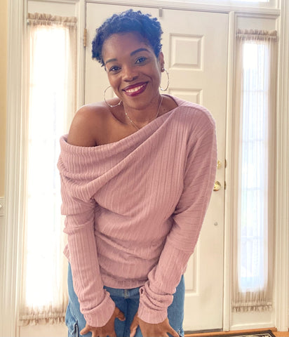 Woman wearing pink off shoulder sweater.