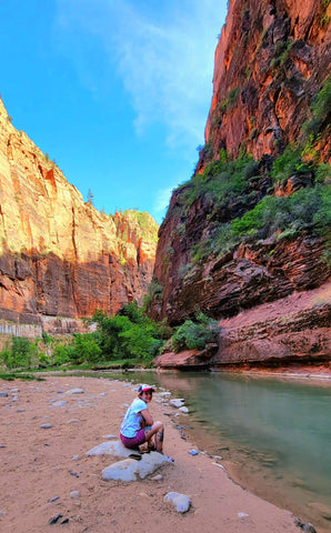 Woman sitting next to a creek