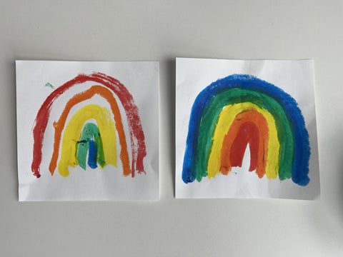 Two drawn rainbows, one on the left with red, orange, yellow, green and blue and one on the right with colors in reverse