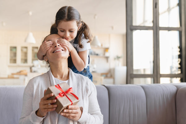 petite fille qui donne un cadeau à sa mère