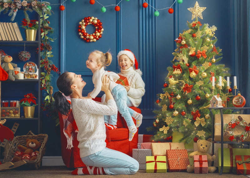 Une mère avec ses enfants découvrant les cadeaux de Noël