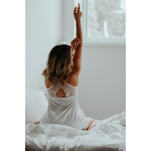 Femme sur le lit portant une chemise de nuit blanche