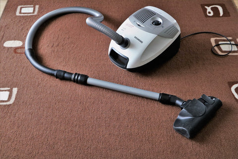 Photograph of a vacuum cleaner placed on a carpet
