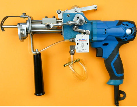 Low-angle view of the AK-II CUT & LOOP pneumatic tufting gun with a blue and black handle placed on a yellow background