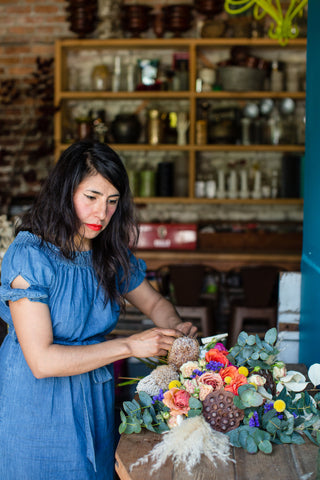 Pilar Zuniga of Gorgeous and Green adding in blooms and textures to a floral door swag