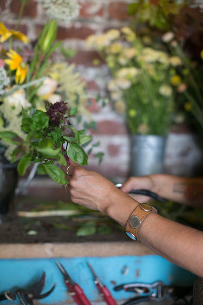 Pilar Zuniga's hands working on a local floral design, without floral foam