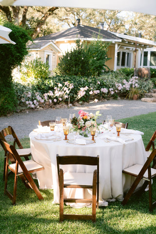 Round table setup with flowers by Gorgeous and Green amber glasses, Beltane Ranch tropical blush look