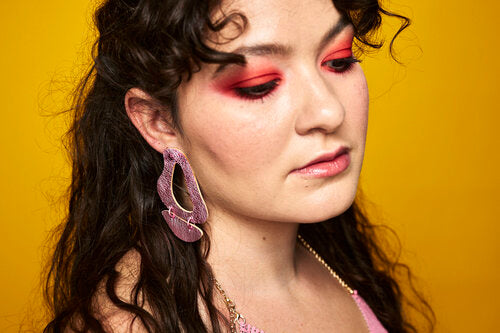 Daniella wears the metallic pink Inferno statement earrings.