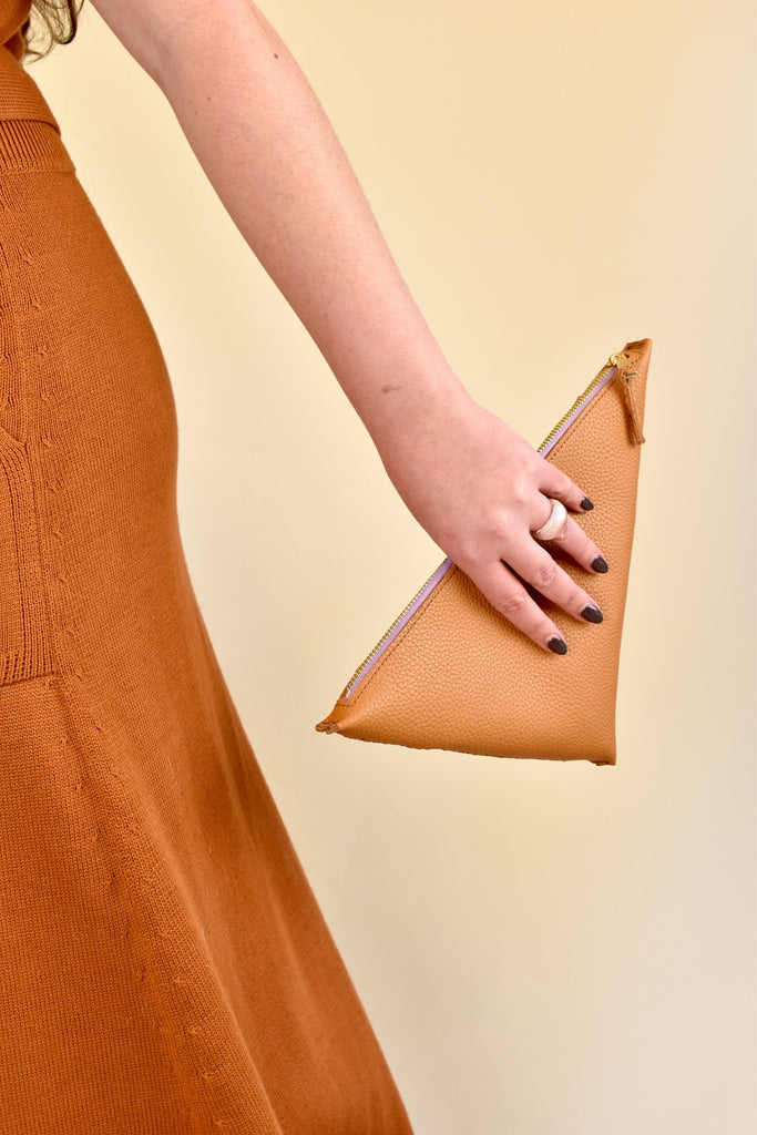 This triangle-shaped leather bag is perfect for adding a stylish touch to a music festival outfit. The earthy sienna color gives it a warm and natural look, making it a versatile accessory that can complement a variety of outfits. The small size of the bag makes it ideal for carrying essentials while keeping your hands free.