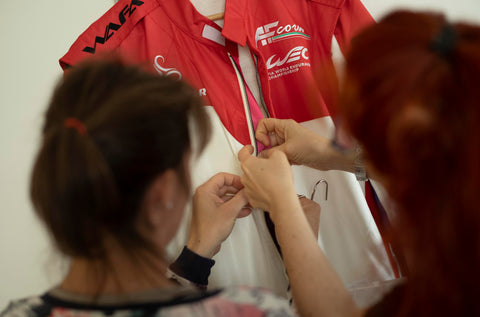 Two people working on a bespoke race suit