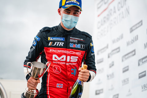 A man holding a trophy wearing bespoke racewear