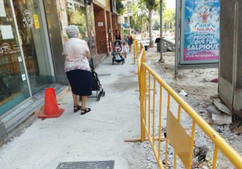 Persona con movilidad reducida sorteando barreras arquitectónicas en la vía urbana