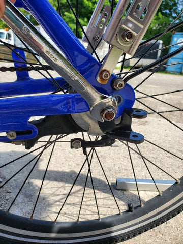 Tightening nut on bolt axle to install bicycle hitch.