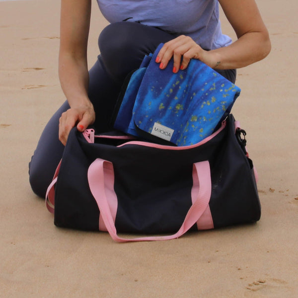 Women keeping folding yoga mat in bag-travel checklist for next trip-mikkoa yoga