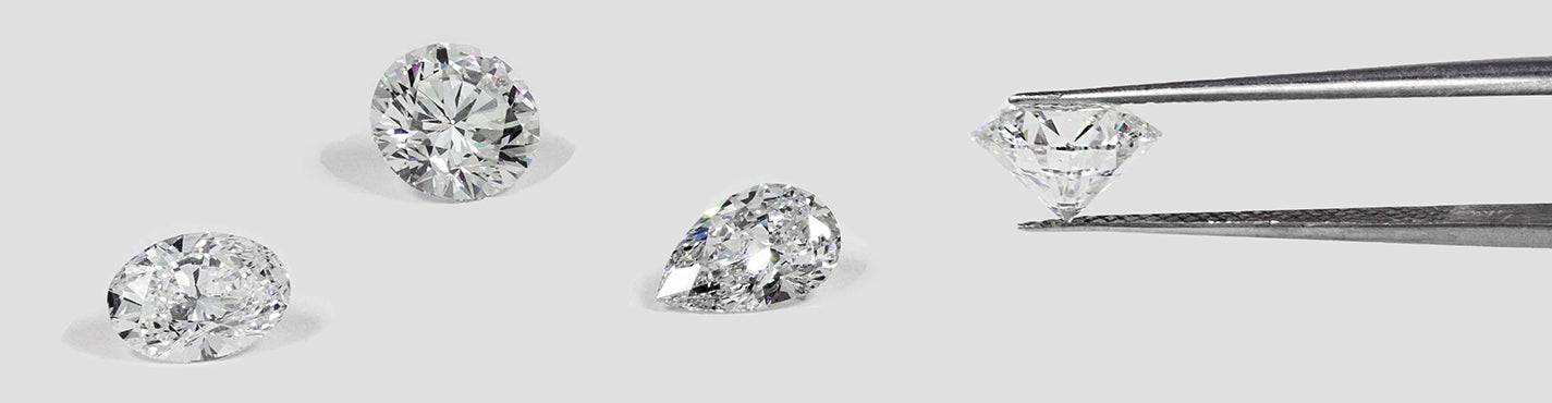 oval, round and pear shaped diamonds with diamond held by long tweezers