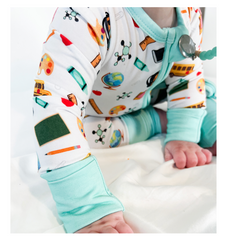 A close picture of a baby wearing a bamboo romper that has school themed graphics on it.