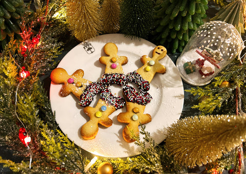 Petits biscuits en forme de bonhommes dans des décorations de forêt vert et doré