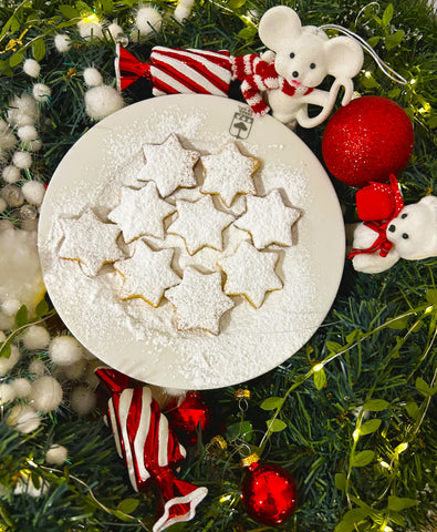 Biscuits en forme d'étoiles blanches dans un décor de Noel vert et rouge