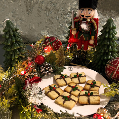 Petits biscuits en forme de cadeaux avec des décorations de Noël rouges et vertes