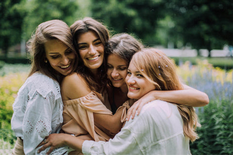 Grupo de amigas mujeres abrazándose.