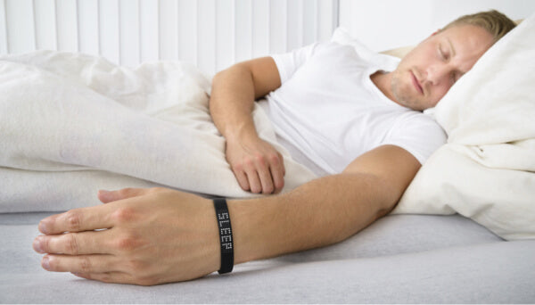 Hombre durmiendo mientras usa un sleep tracker.